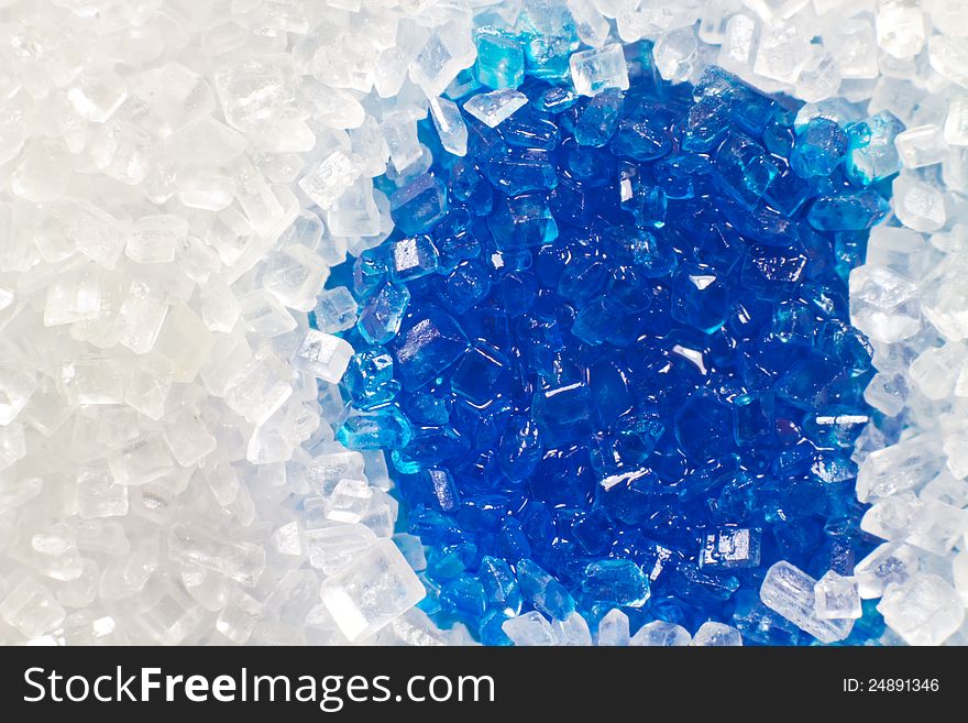 A macro picture of white sugar with blue liquid. A macro picture of white sugar with blue liquid