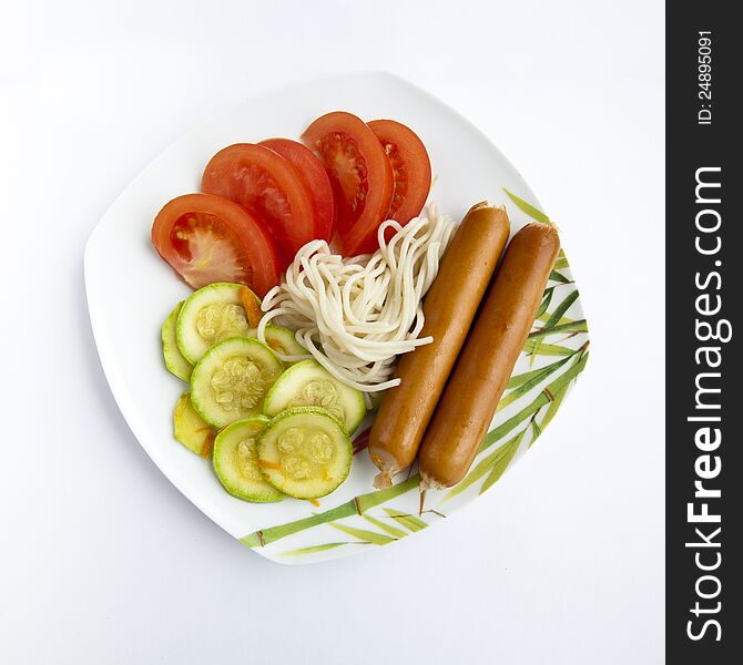 Spaghetti, tomato cabbage , sausage on a plate isolated on white