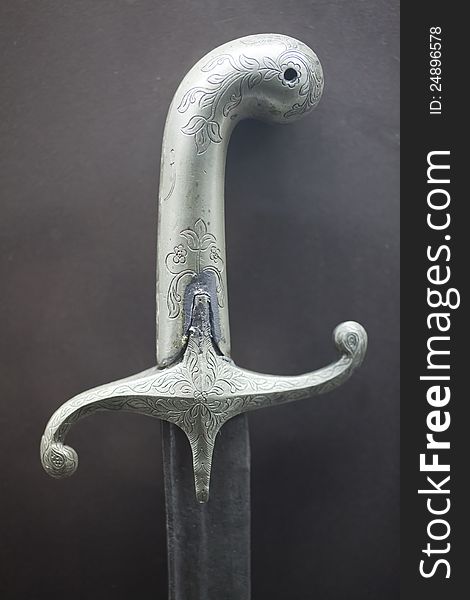 Old silver sword on grey background