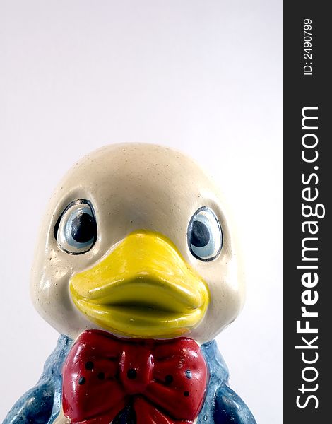 Closeup of funny ceramic duck piggy bank isolated on white background.