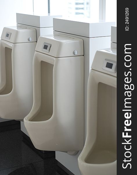 3 three urinals in an office toilet