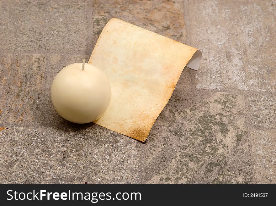 Very old paper with a candle  in a stone ( very textured stone)