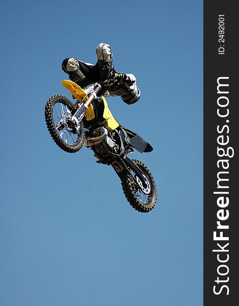 A stunt biker high up in the air.  All logos and trademarks removed digitally.
