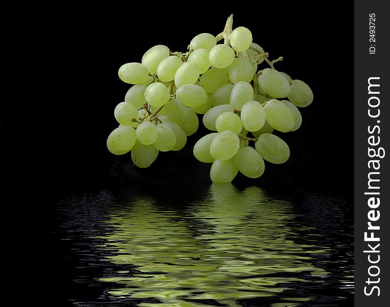 Green grapes with a water reflection on a black background. Green grapes with a water reflection on a black background