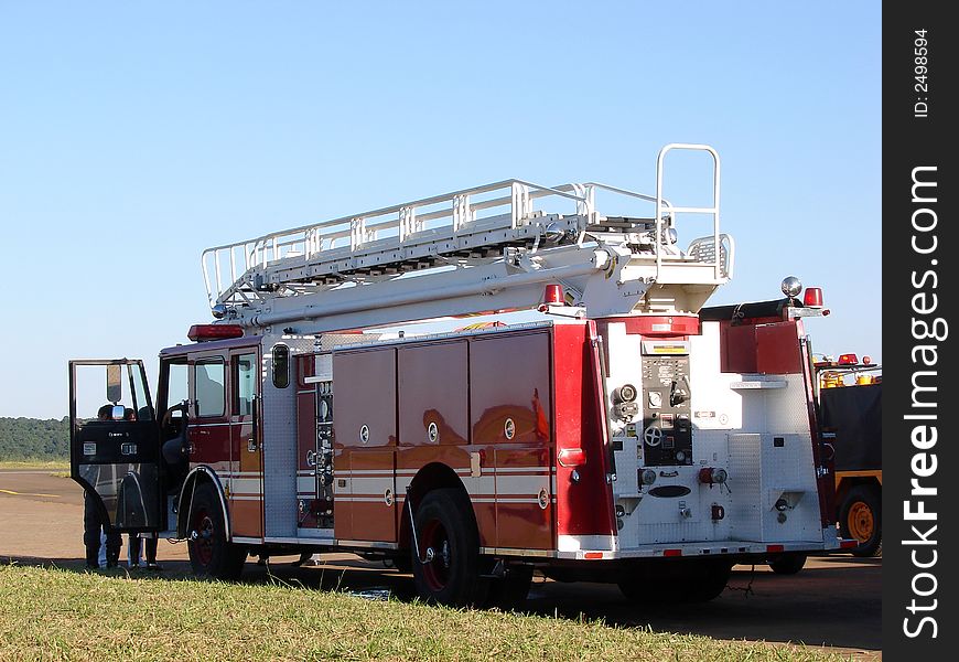 A red fire truck parked in a field.