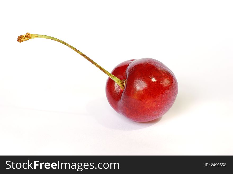 Single red ripe cherry shot against a white background. Single red ripe cherry shot against a white background
