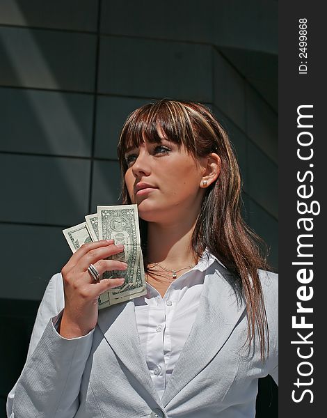 A portrait of a woman downtown with dollars in a hand. A portrait of a woman downtown with dollars in a hand