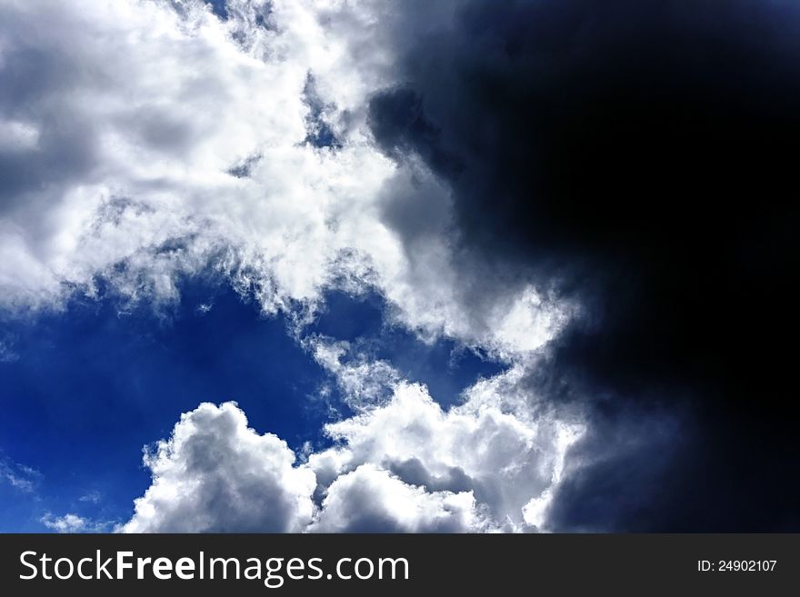 A blue sky with lighten white and dark black clouds. A blue sky with lighten white and dark black clouds