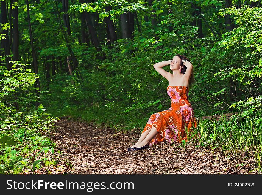 Young woman sitting in forest