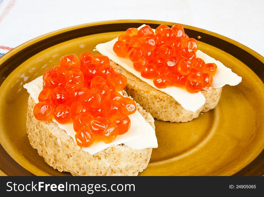 Red caviar sandwich on small ceramic plate