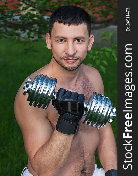 Portrait of young man holding dumbbell outdoors. Portrait of young man holding dumbbell outdoors