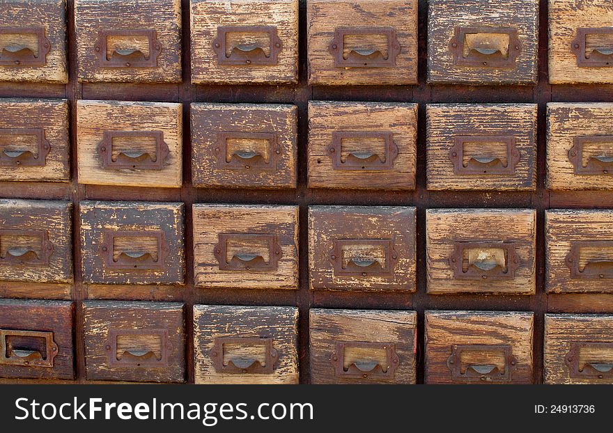 Close-up of a bank of worn wooden file card drawers. Suitable for background. Close-up of a bank of worn wooden file card drawers. Suitable for background.