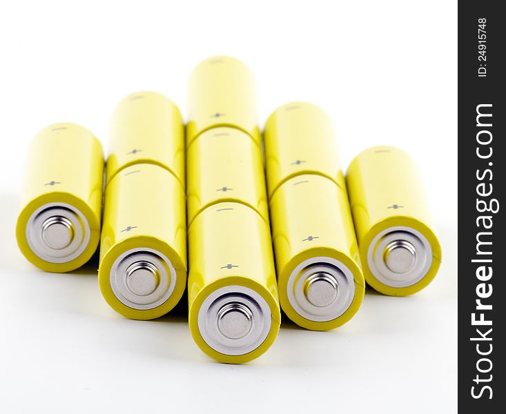 Arrangement of colorful yellow Batteries on white background