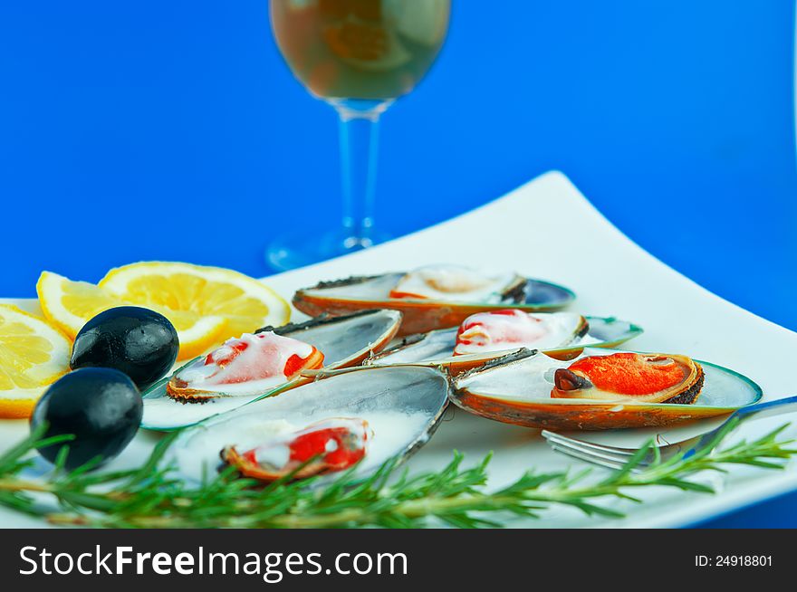 A dish with mussels with sauce bechamel with olives, lemon and rosemary. A dish with mussels with sauce bechamel with olives, lemon and rosemary