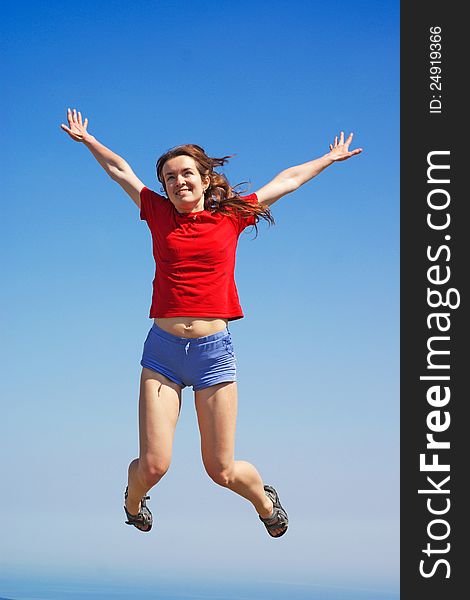 Young and happy woman is jumping at sea and sky background. Young and happy woman is jumping at sea and sky background
