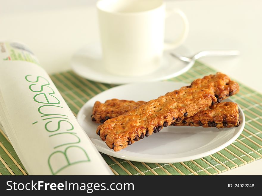 Cup coffee pastry chocolate chips and whitebackground