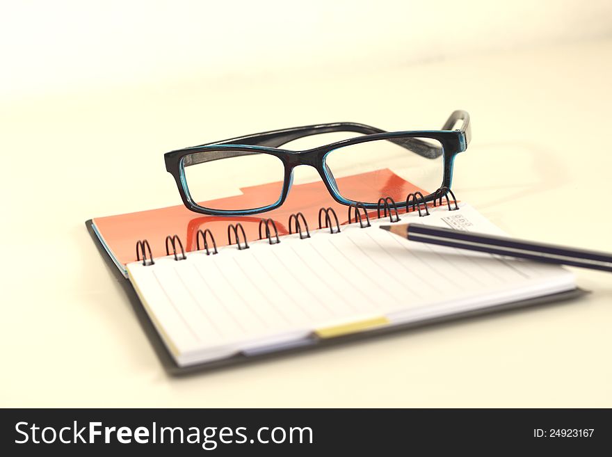 Black notebook cover Glasses and a pencil