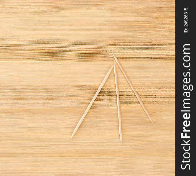 Three toothpicks on a wooden table