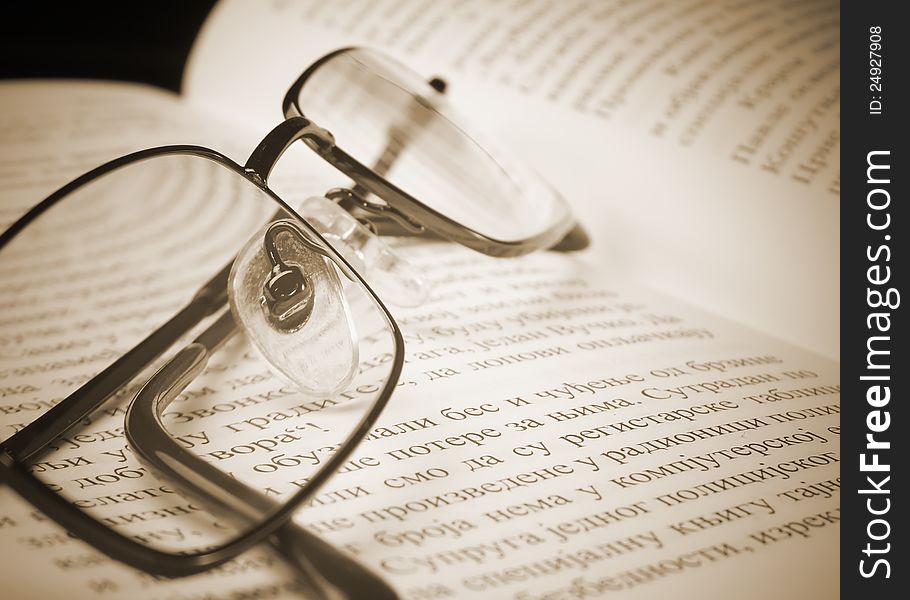 Eyeglasses on the old thick book. A photo close up