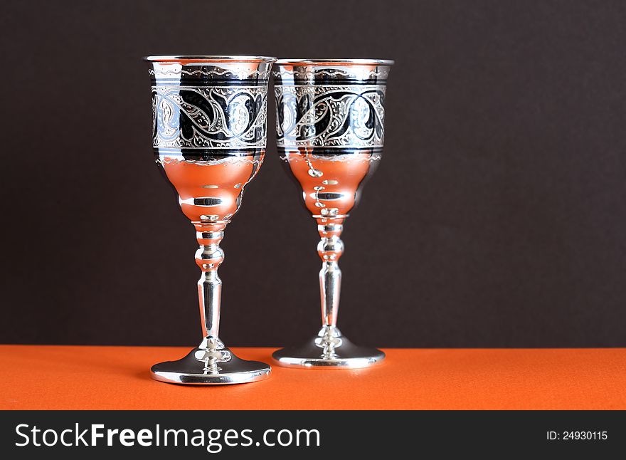 Pair of nice vintage silver goblets on ginger and dark background