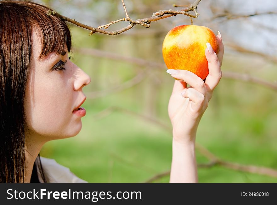 Portrait of beautiful young girl picking the apple