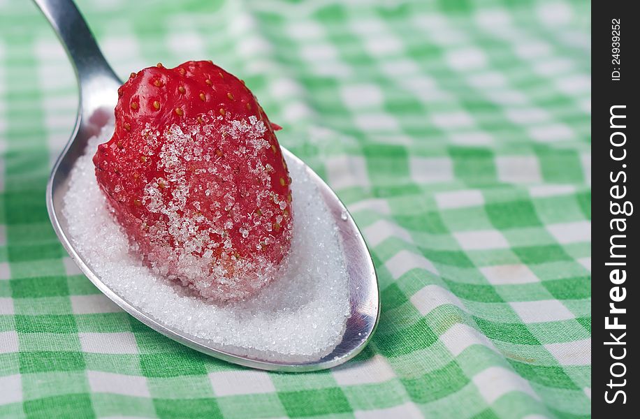 Fresh strawberries dipped in sugar on a spoon