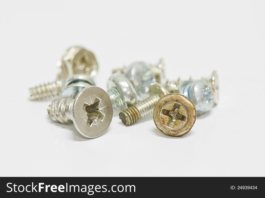 Little screws on white background with shallow focus