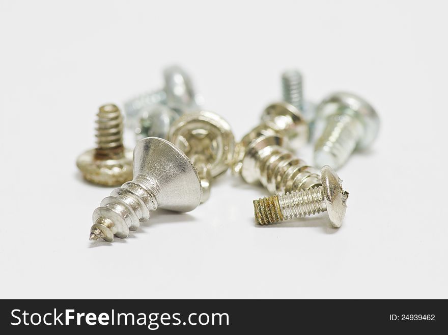 Little screws on white background with shallow focus