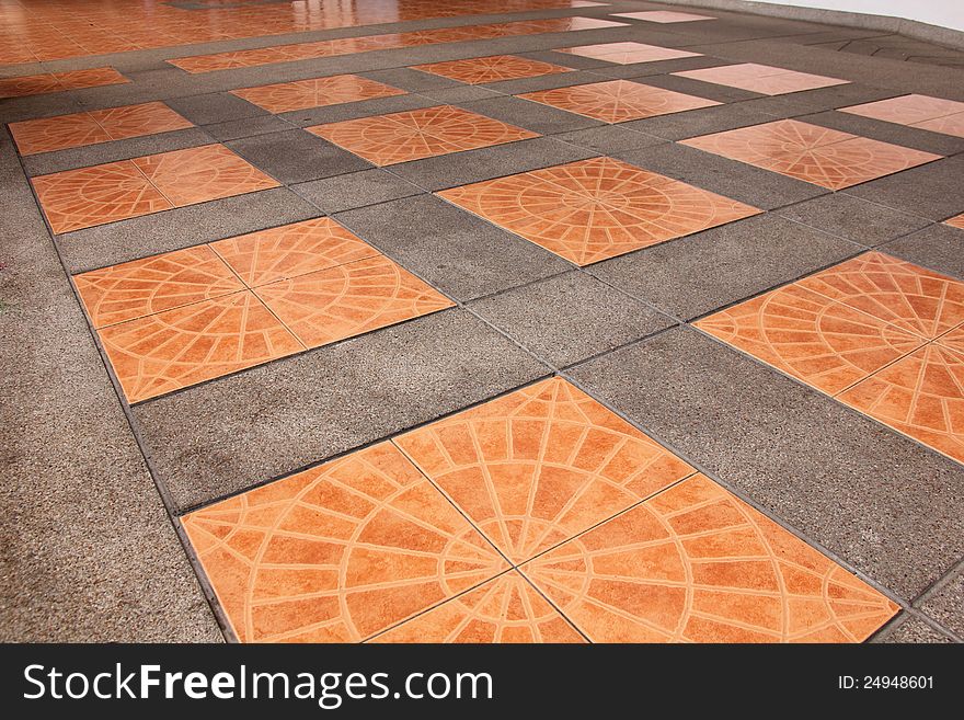 Orange square tiles on the pavement.