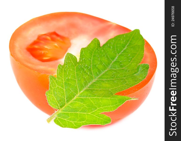 A half of red tomato with a green leaf on a white background. A half of red tomato with a green leaf on a white background