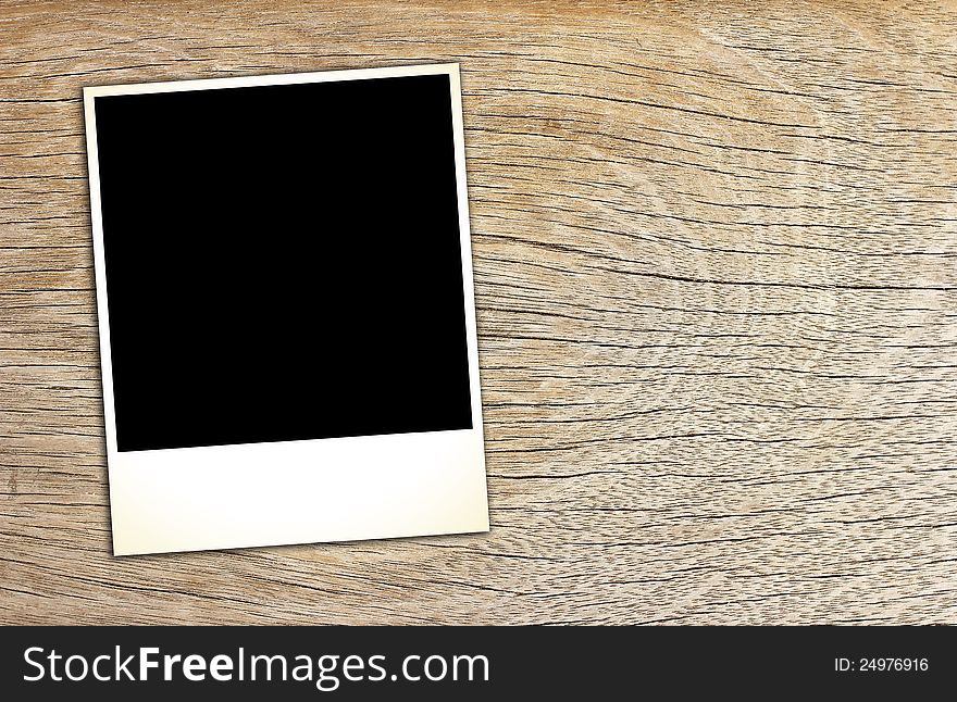 Blank vintage paper and photo frame on wooden background