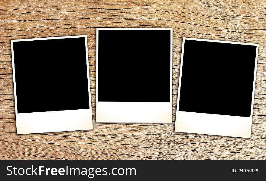 Blank vintage paper and photo frame on wooden background