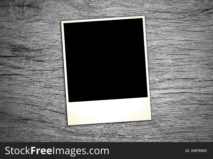 Blank vintage paper and photo frame on wooden background