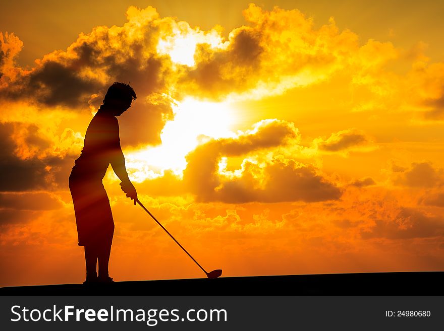 Image of Silhouette golfer at sunset