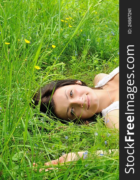 Girl lying on green grass and looking to the camera. Girl lying on green grass and looking to the camera