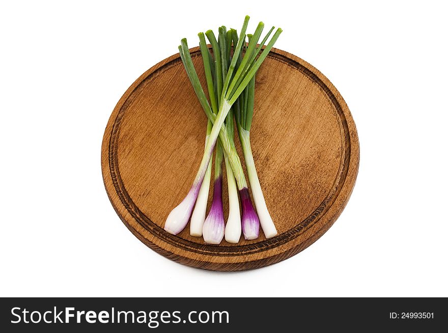 Spring onions on a wooden mat