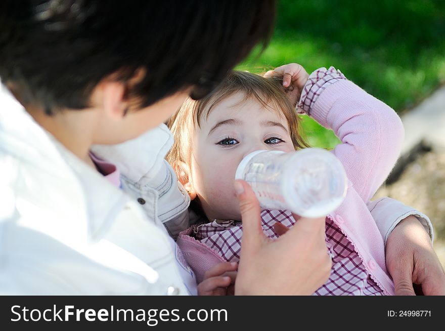 Mother Feeding Her Baby Girl With Feeding Bottle