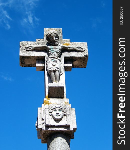 This is a religious symbol, a stone cross with a christ sculptured. This is a religious symbol, a stone cross with a christ sculptured