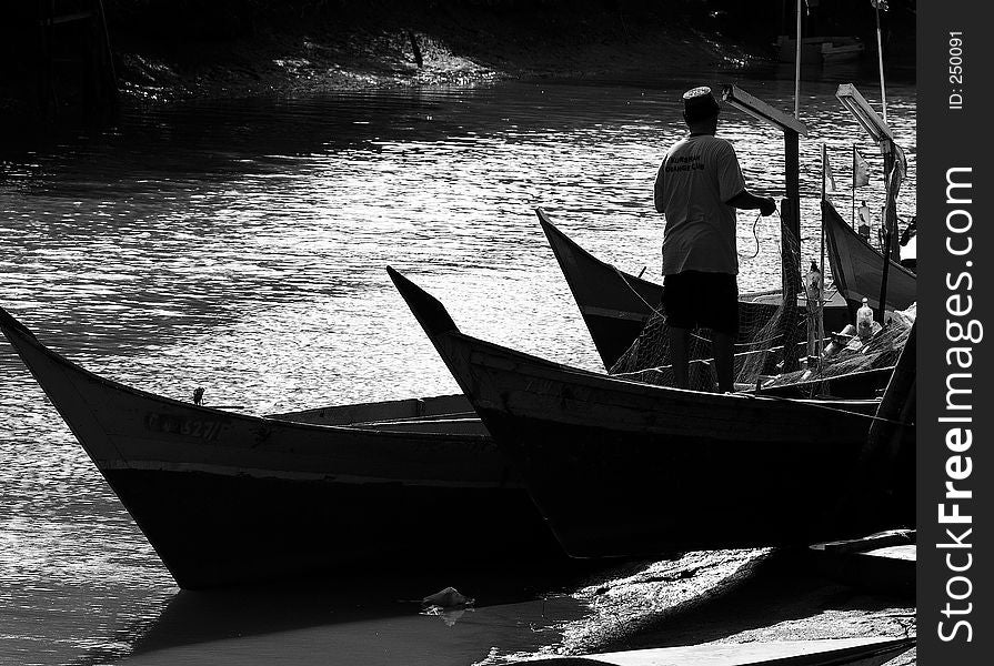 Silhouetted boats in a fishing village. Silhouetted boats in a fishing village