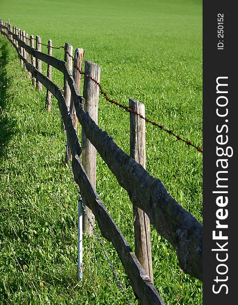 Fence bordering green meadow