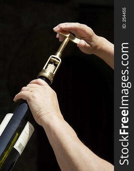 Hand uncorking a wine bottle