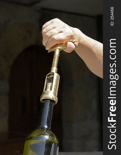 Hand uncorking a wine bottle