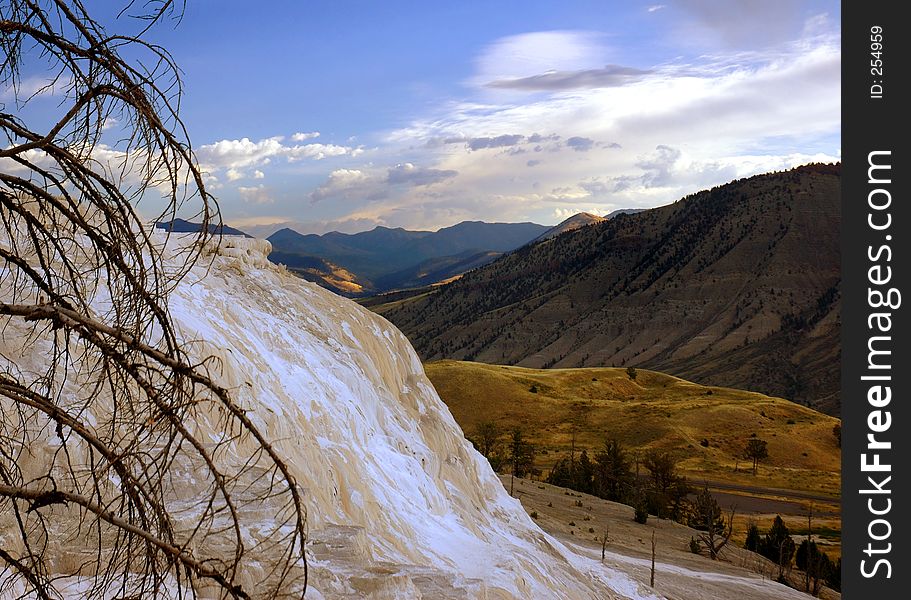 View of terrace of Mammoth Hot Springs with the mountains of Yellowstone National Park, Wyoming in the background. View of terrace of Mammoth Hot Springs with the mountains of Yellowstone National Park, Wyoming in the background