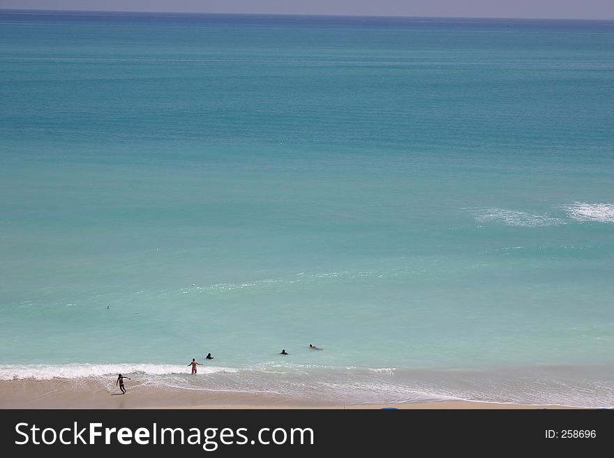Vacation type photo of blue ocean and people playing in surf. Vacation type photo of blue ocean and people playing in surf