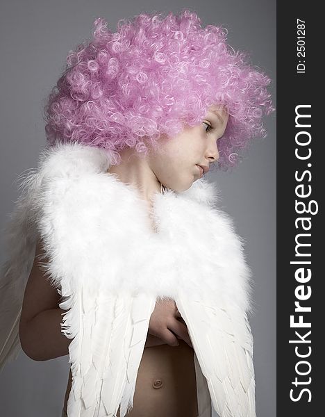 Little boy in pink wig and angel wings on plain background. Little boy in pink wig and angel wings on plain background