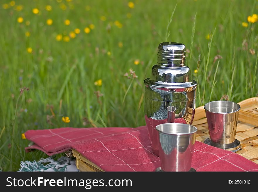 Basket of picnic in grass posed on a tablecloth