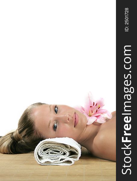 Portrait of a fresh and beautiful blond woman on a towel with flowers with closed eyes. Portrait of a fresh and beautiful blond woman on a towel with flowers with closed eyes