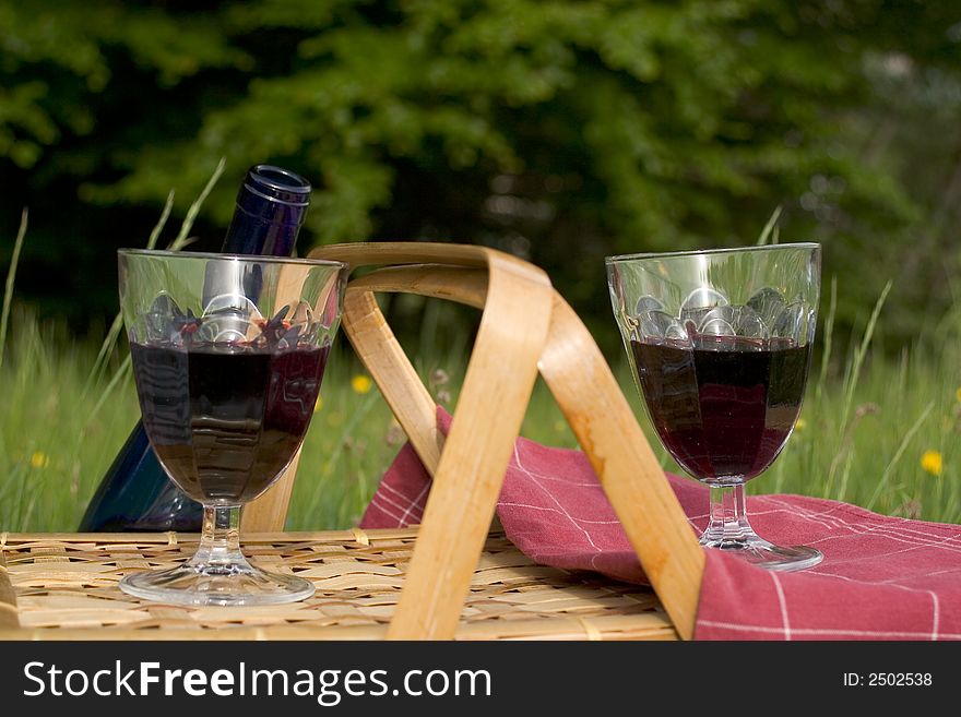 Basket of picnic in grass posed on a tablecloth