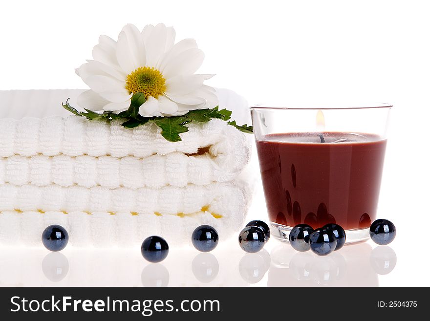 Towels, candle, and daisy on white isolated. Towels, candle, and daisy on white isolated