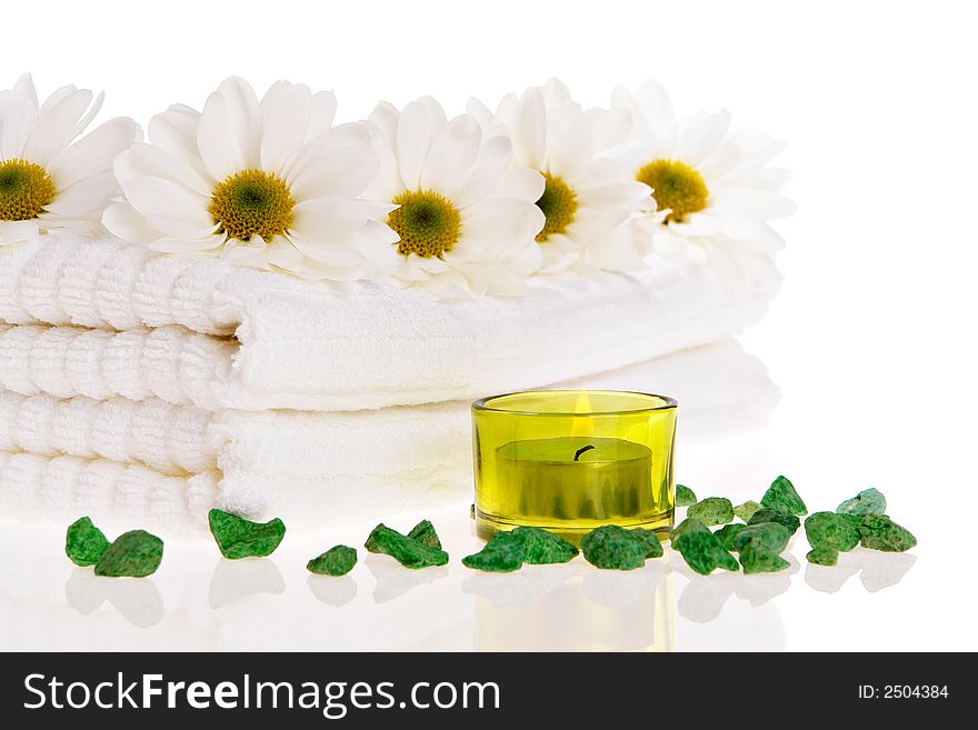 Towels, candle, and daisies on white isolated. Towels, candle, and daisies on white isolated